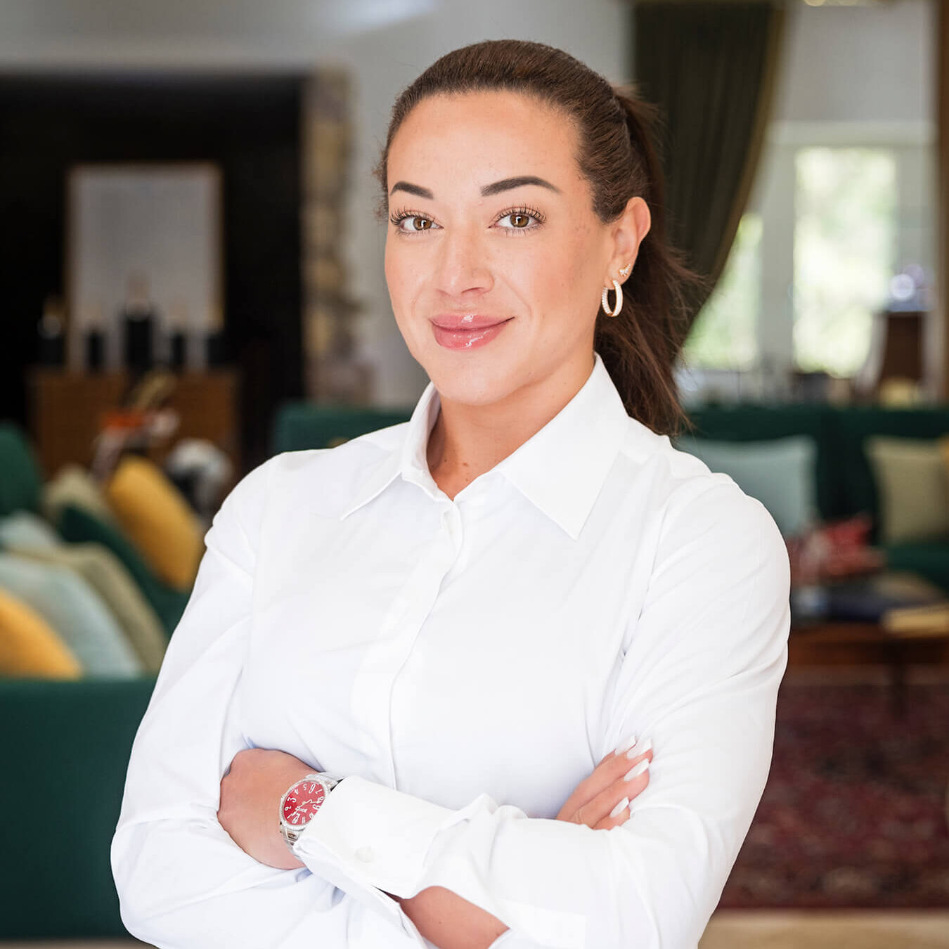 Elegant woman wearing a Bovet timepiece, standing confidently in a luxurious, well-lit interior sett.