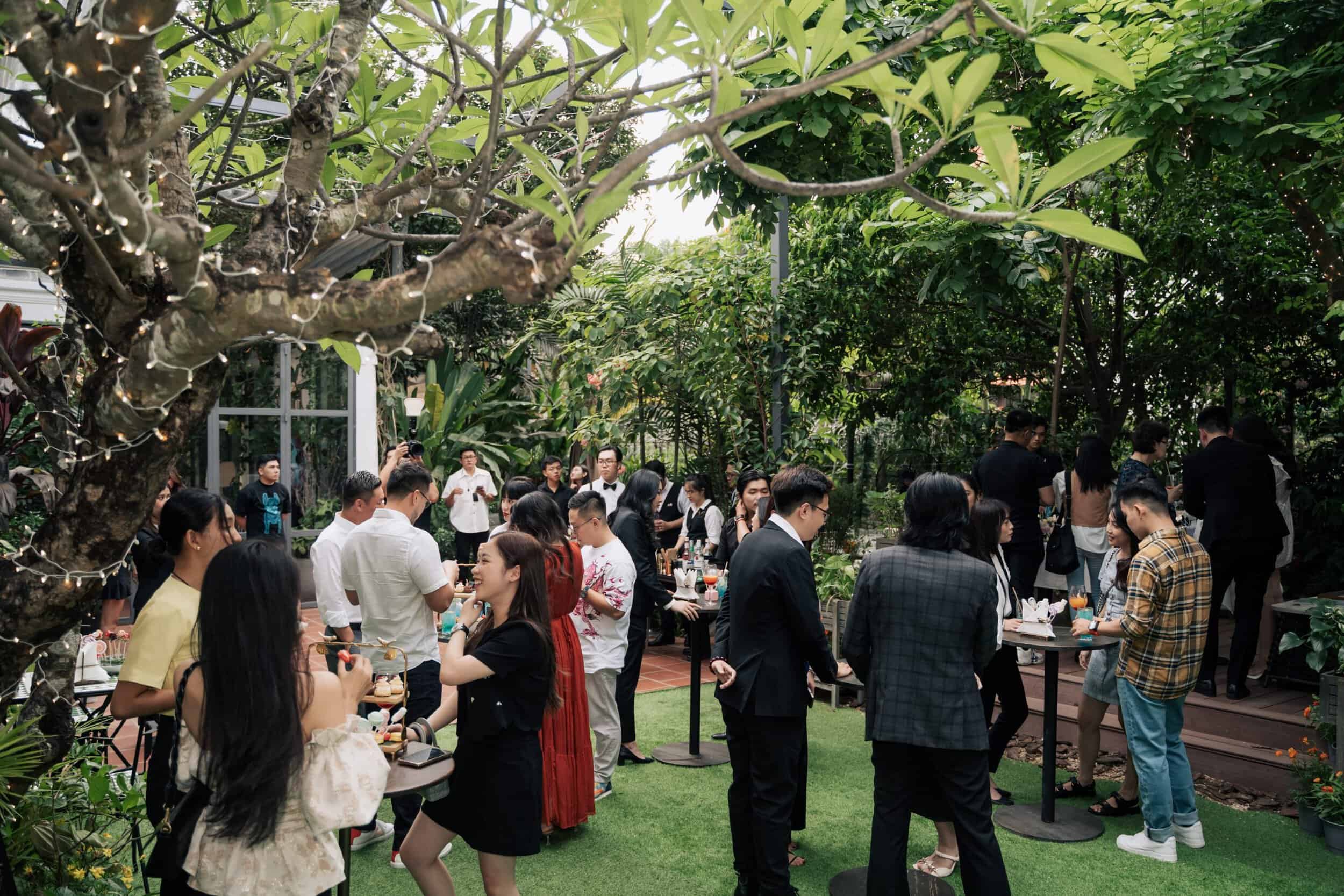 Elegant outdoor gathering showcasing luxurious timepieces in a lush garden setting.
