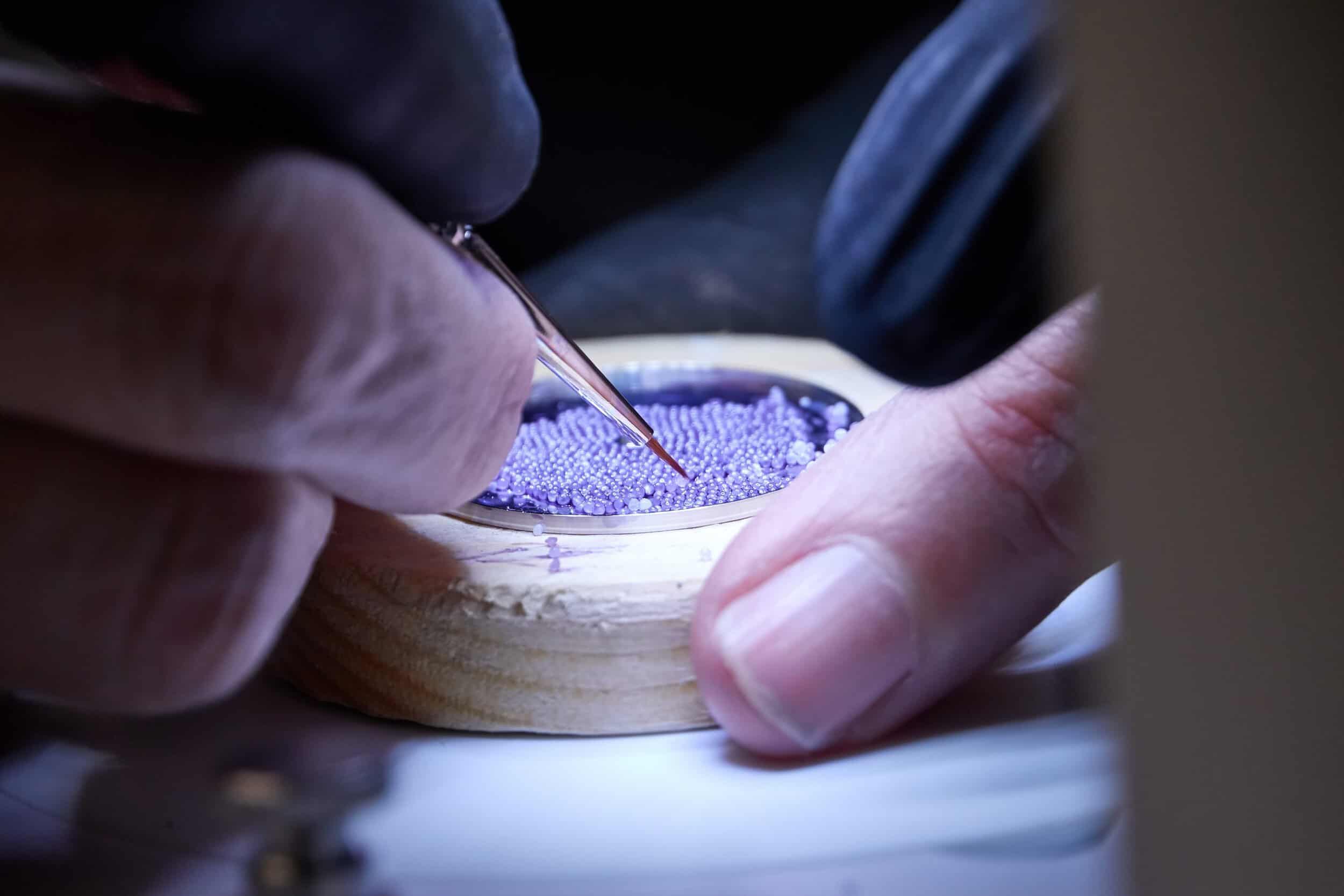 A detailed close-up of artisan crafting a luxury timepiece component with precision.