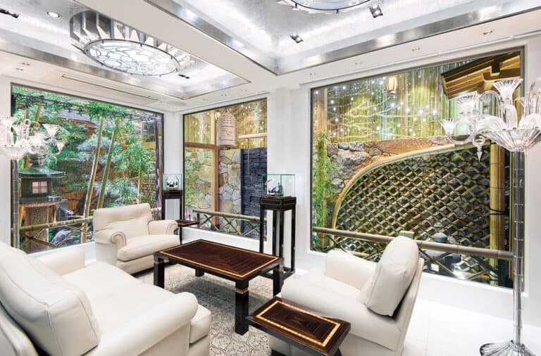 Elegant Bovet timepieces displayed in a luxurious store interior with lush greenery outside.