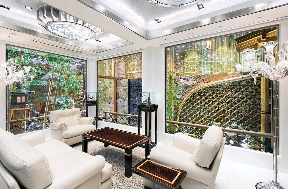 Elegant Bovet timepieces displayed in a luxurious store interior with lush greenery outside.